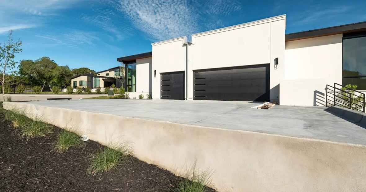 Broad new driveway curing in front of a just-finished build